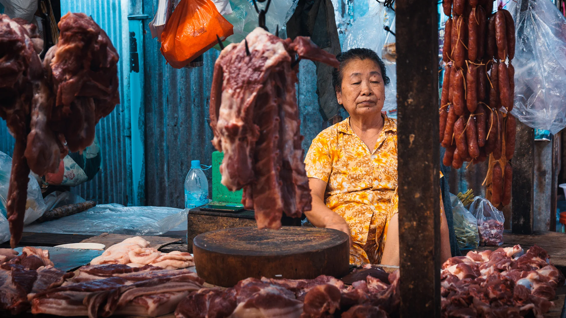 Old meat seller in russian market during a Food tour Phnom Penh