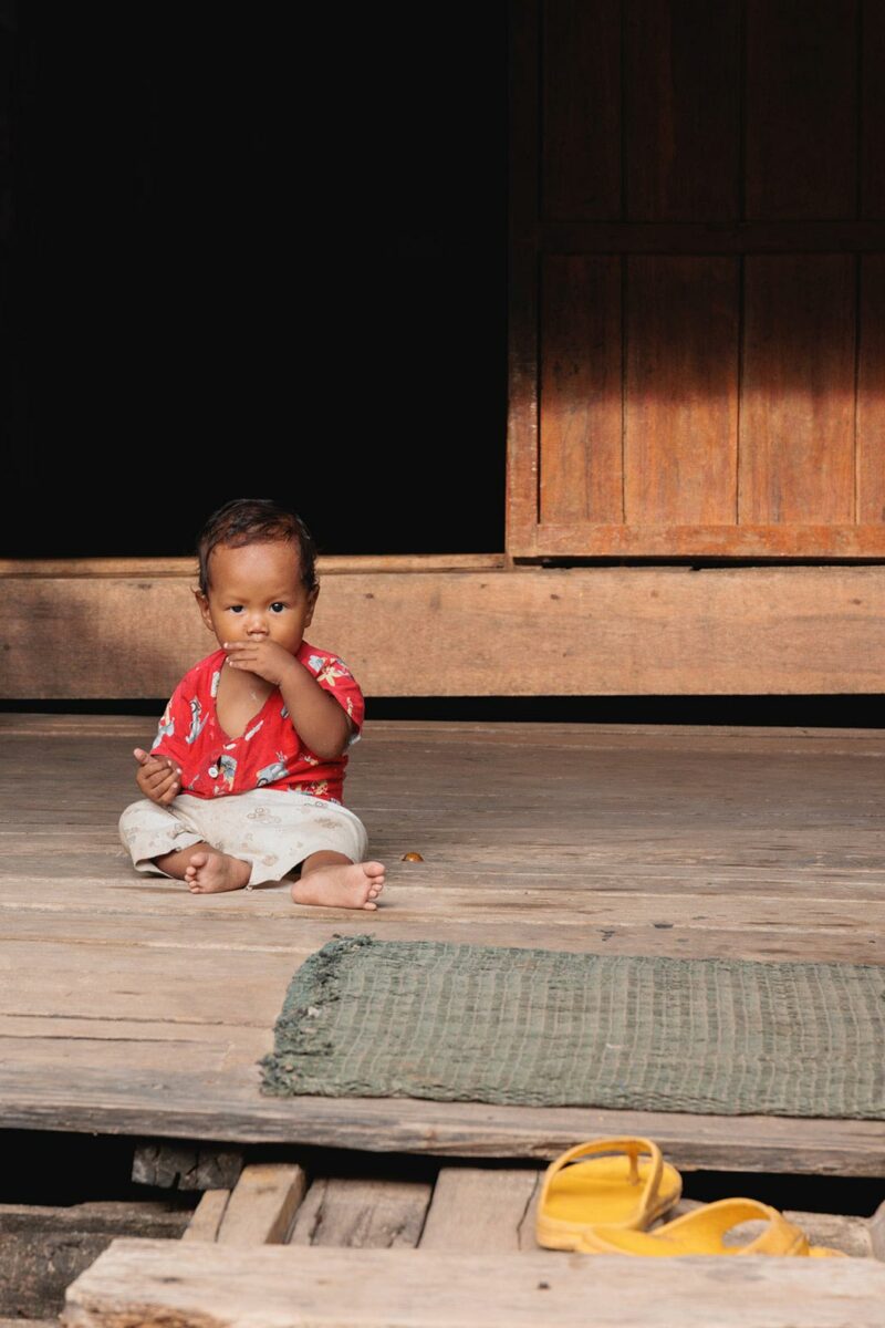 Baby portrait in front of a wooden house in the village of M'Pai Bay, Koh Rong Sanloem, Cambodia