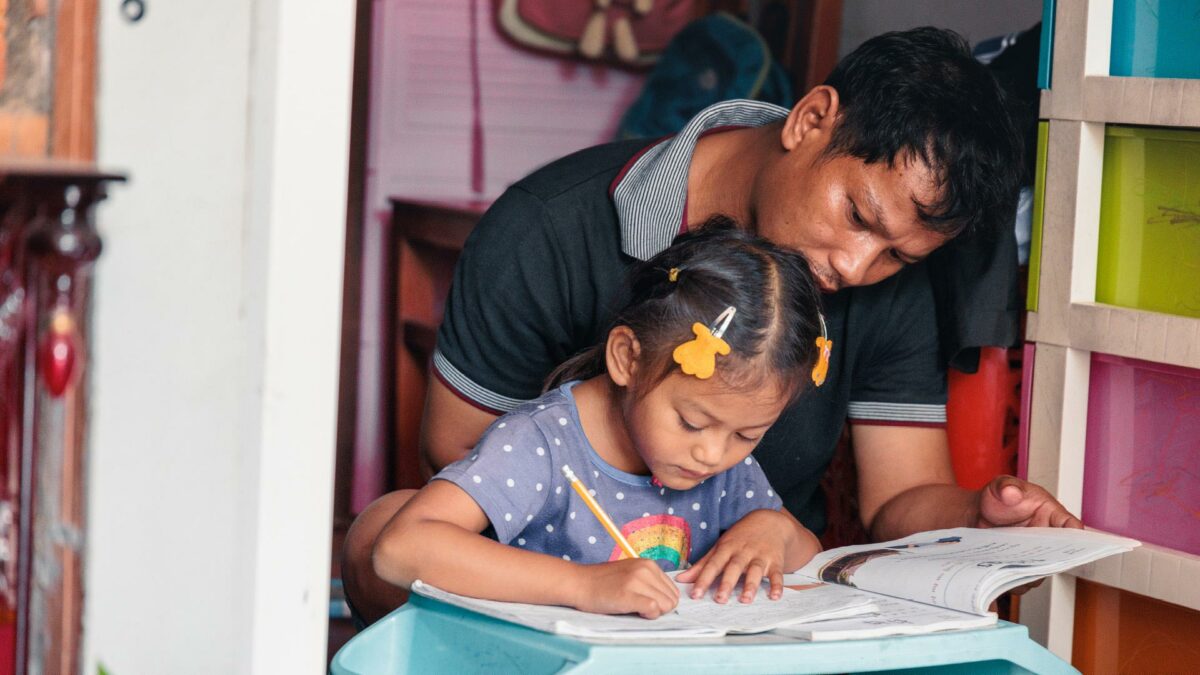 Ing Ing, the daughter of the island,  doing her home work with her father
 