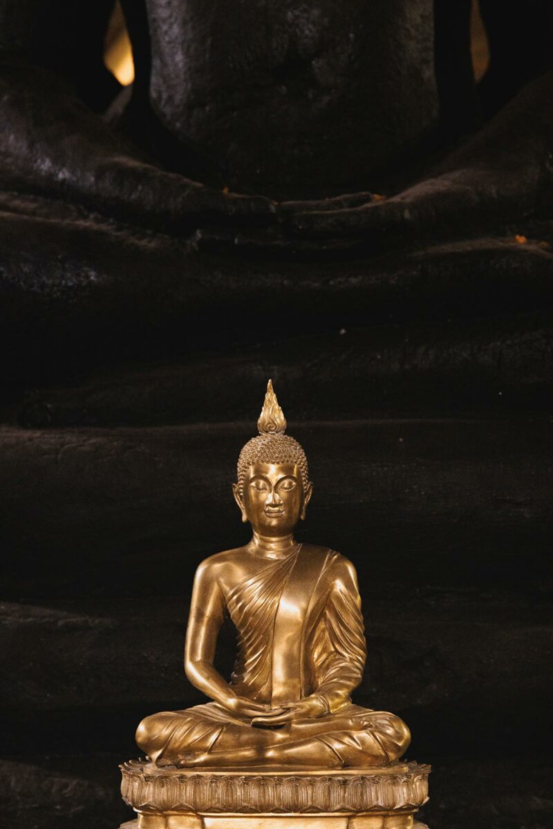 Golden Buddha in front of a black stone Buddha - Wat Ratchabophit Sathitmahasimaram Ratchaworawihan - Bangkok.