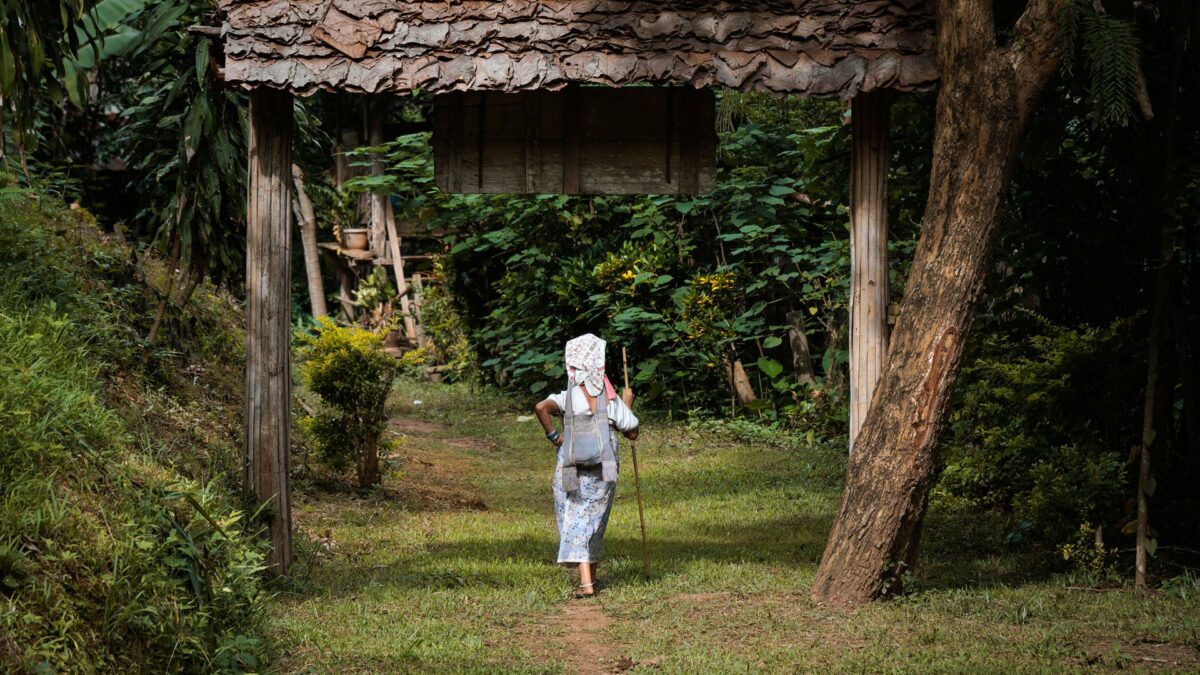 Mu Kler, walking with he stick in the village of Huay Pu Keng