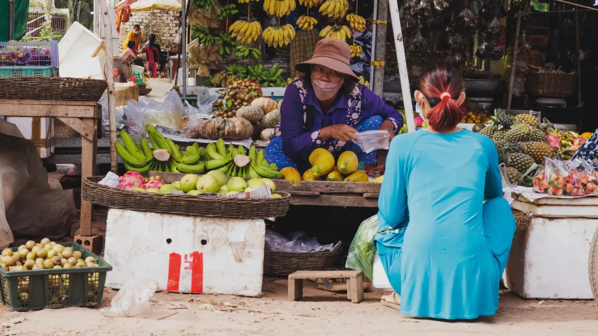 Women negotiating fruits in a market in Siem Reap, Cambodia
