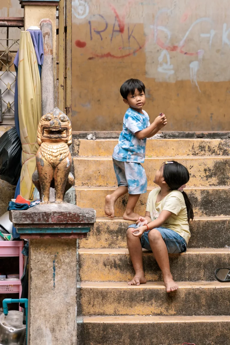 Street kids playing on the stairs of a temple in Phnom Penh Cambodia
