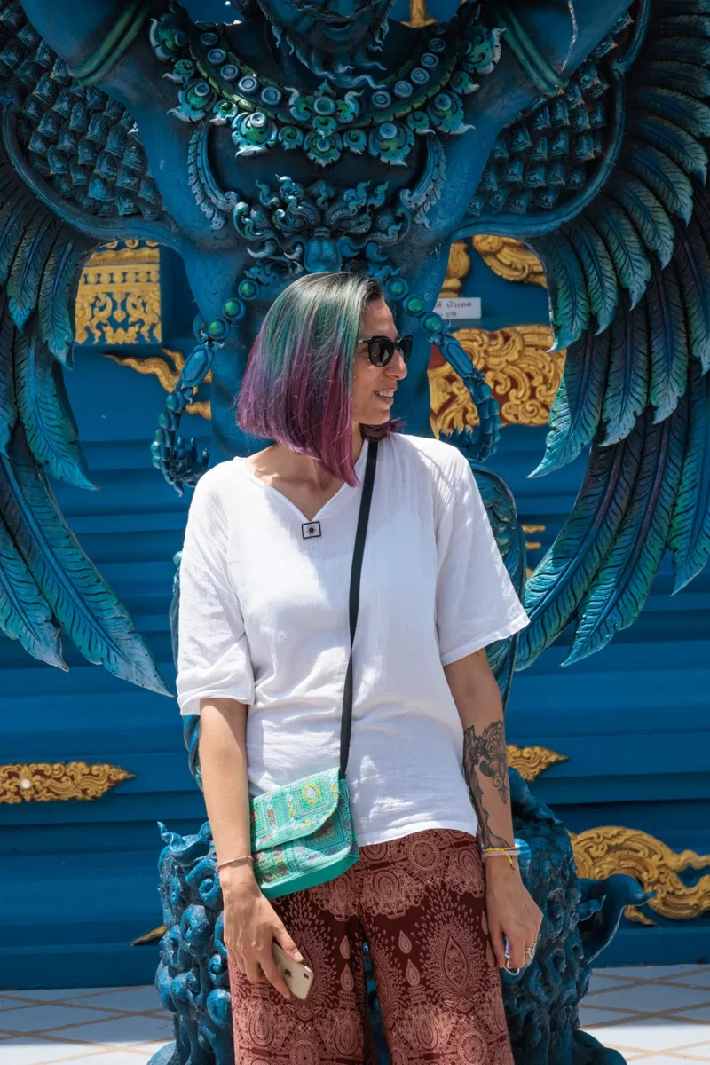 Francesca Simoni, with blue wings in front of the blue temple in Chiang Mai, Thailand
