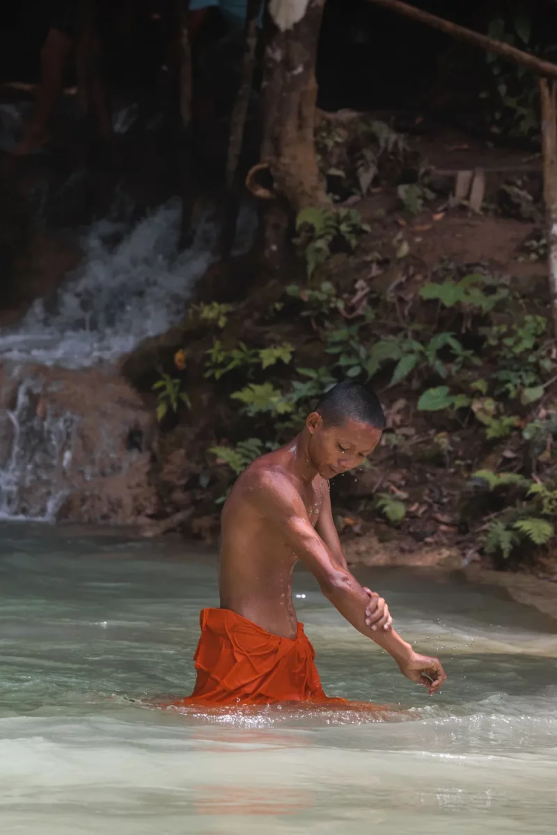Young Monk washing himself in Tat Sae Waterfalls - Luang Prabang, Laos