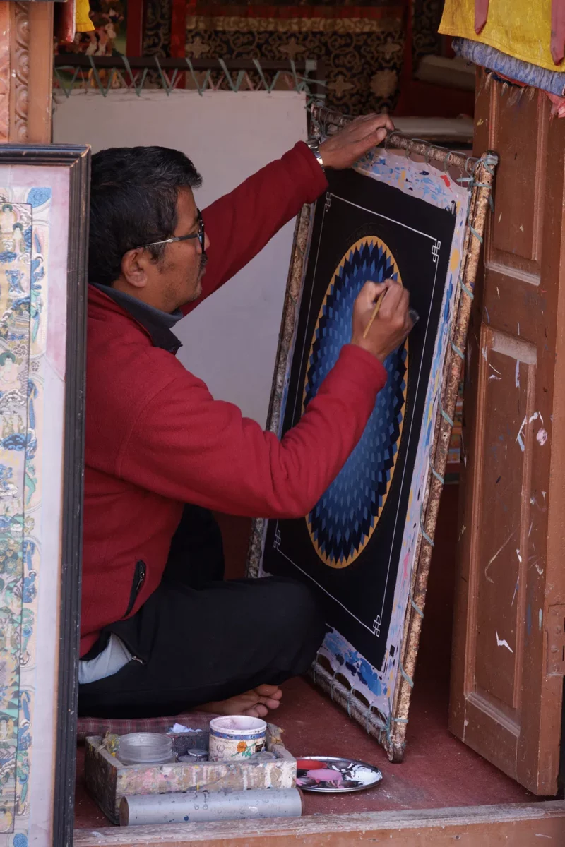 Thangka mandala school teacher correcting a painting, Changunarayan, Nepal