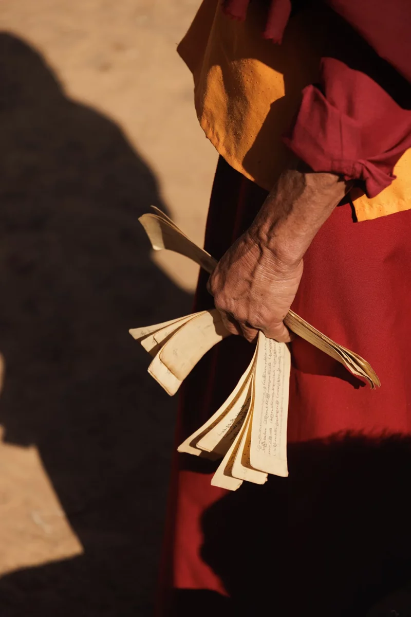 Lama holding prayer scroll during a ceremony in the mountain of Nepal - This Human Tribe