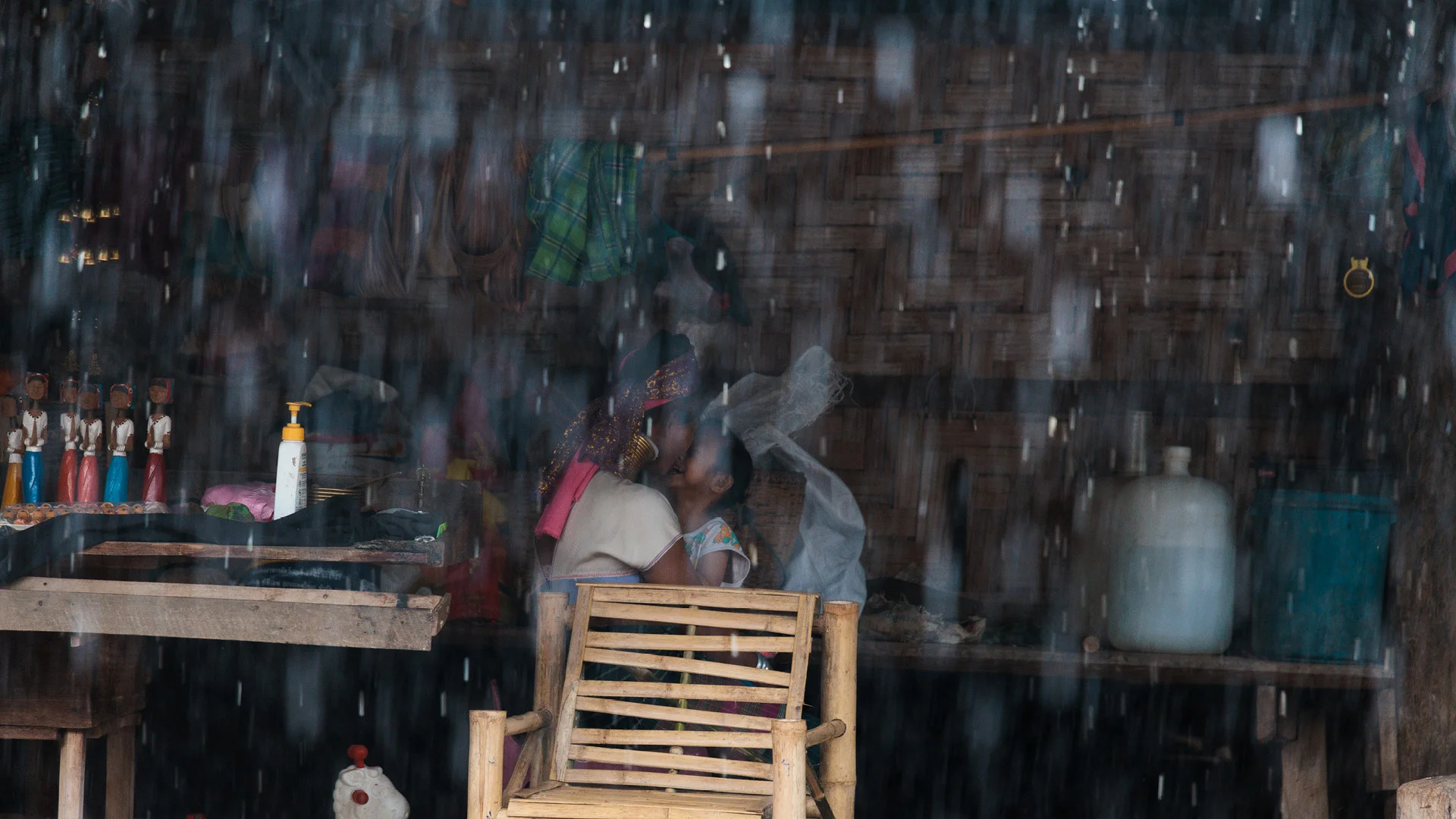 Mother and daughter kissing during heavy rain in Huay Pu Keng, close to Mae Hong Son, Thailand