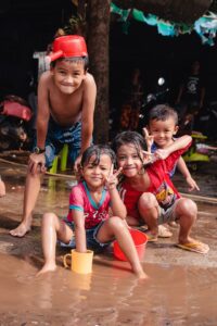 Young kids posing in a puddle during New year in Cambodia