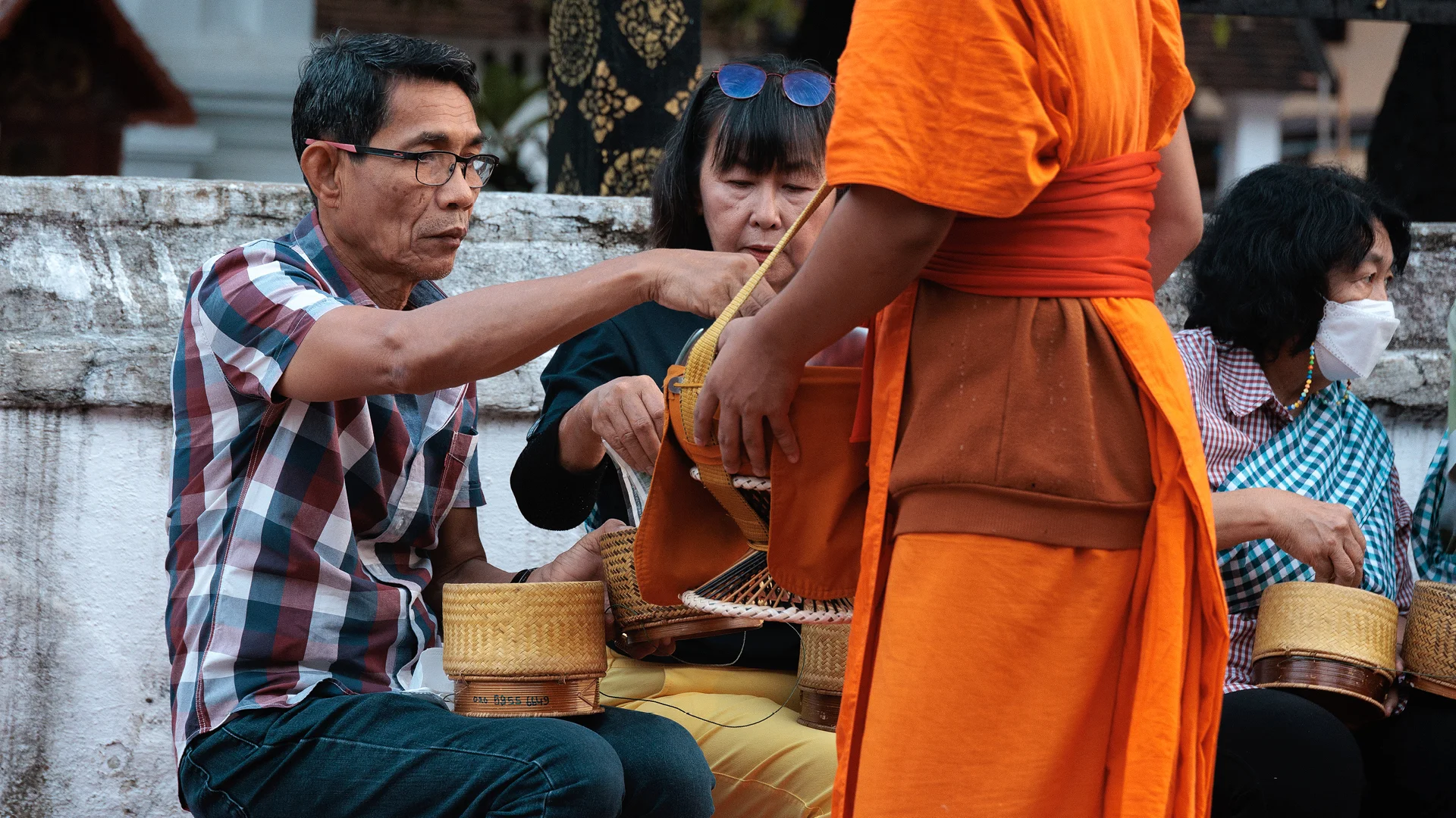 Monk recieving food in Luang Prabang during the alms ceremony