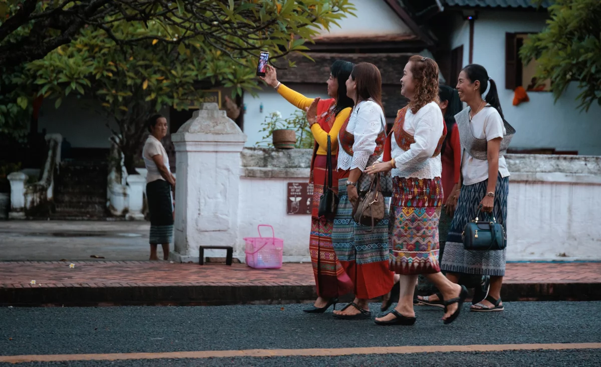 Asian tourist during alms ceremony in Luang Prabang Ethical tourism in Southeast Asia