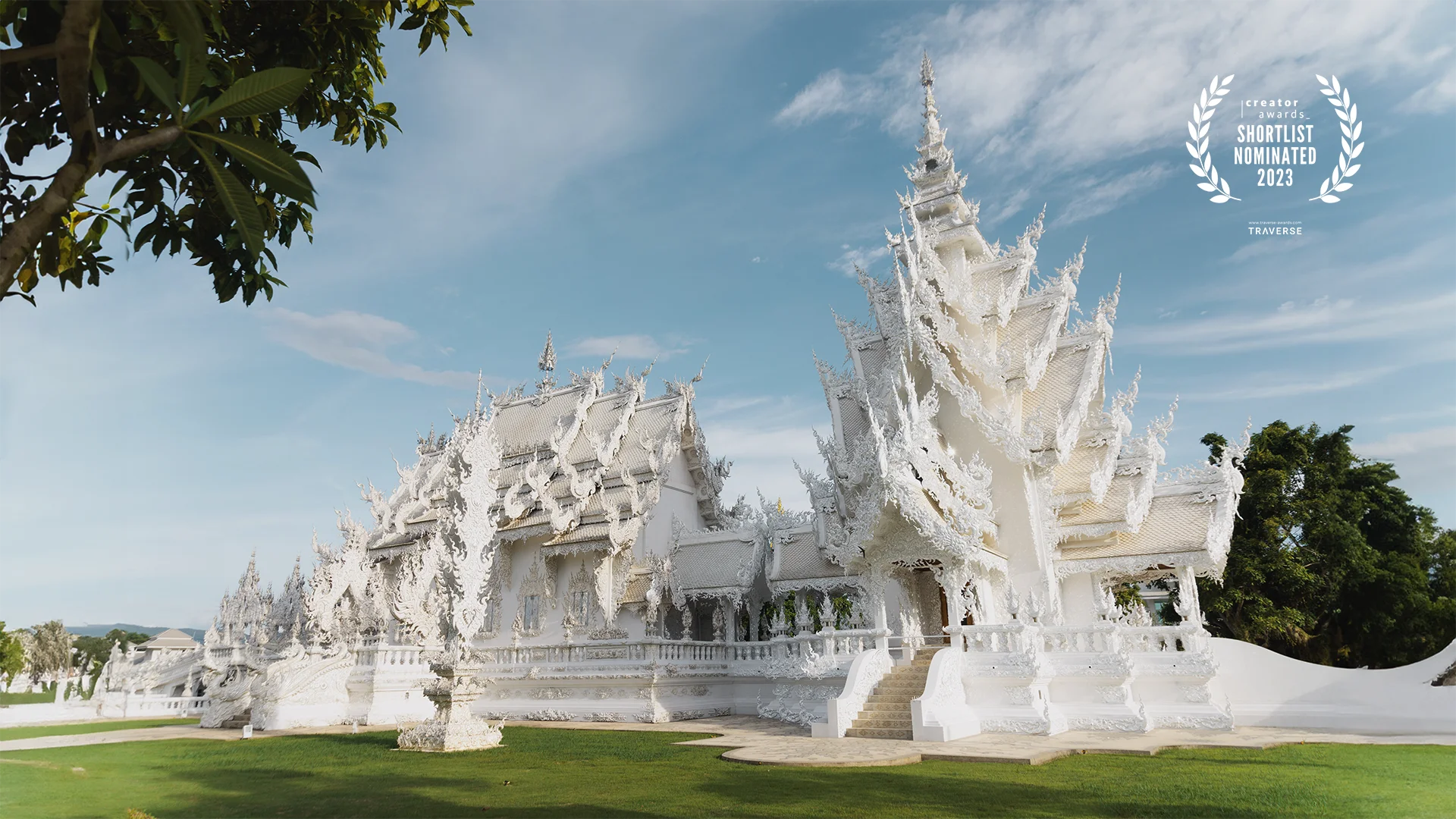 Wat Rong Khun - White Temple, built by Chalermchai Kositpipat Chiang Rai, Thailand side views, blue sky