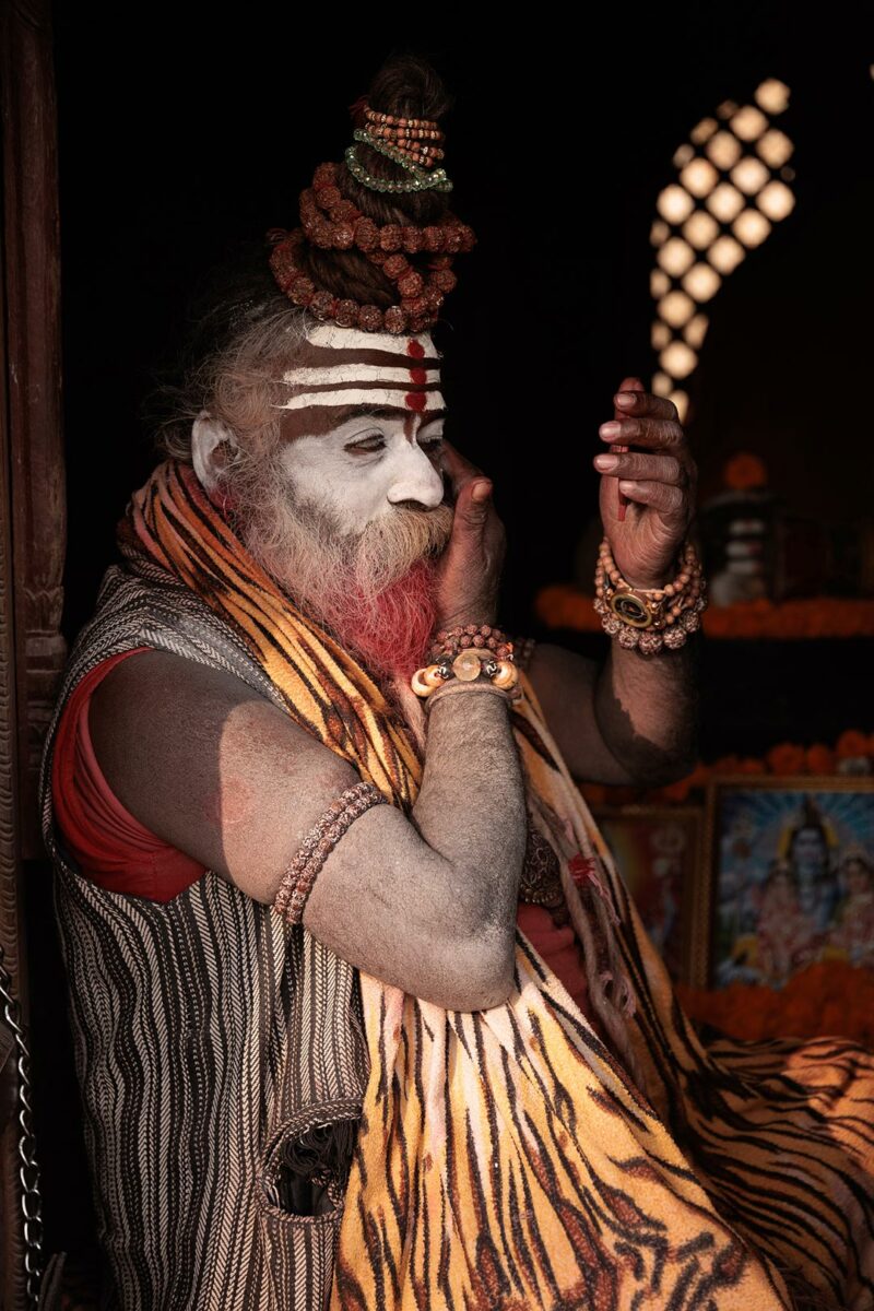 Portrait of a Sadhu doing his makeup in Pashupatinath temple Nepal