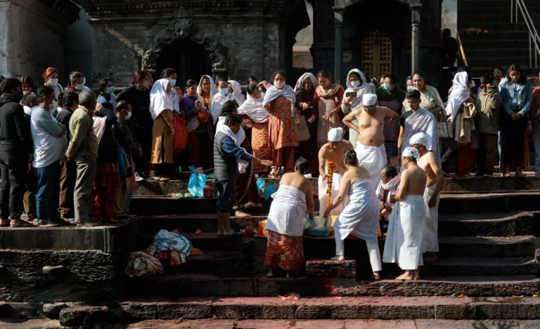 Family and worshiper preparing a body before a cremation in Pashupatinath temple Nepal