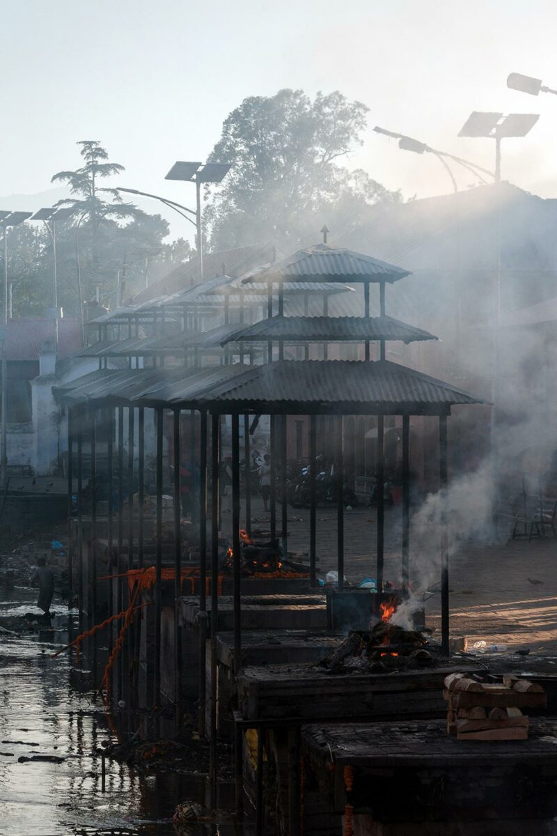 Visit Pashupatinath temple. Smoke covers the cremation ground during the cremation ritual.