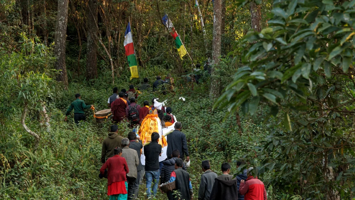 Remote nepalese village ritual of cremation, a group of villager entering a forest holding the corpse of a deceased loved one