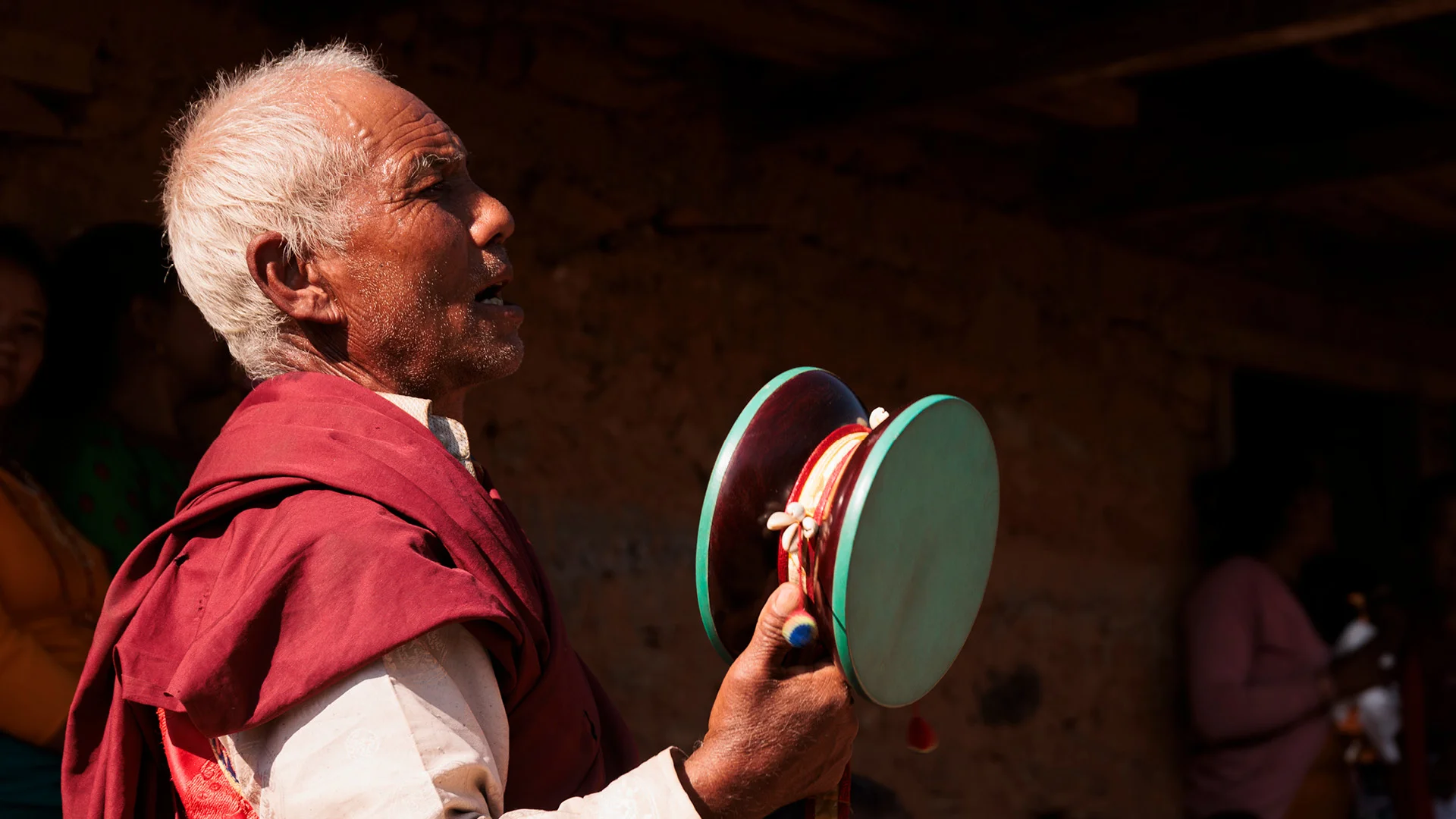 Great lama praying and playing drums during a sacred dance in nepal