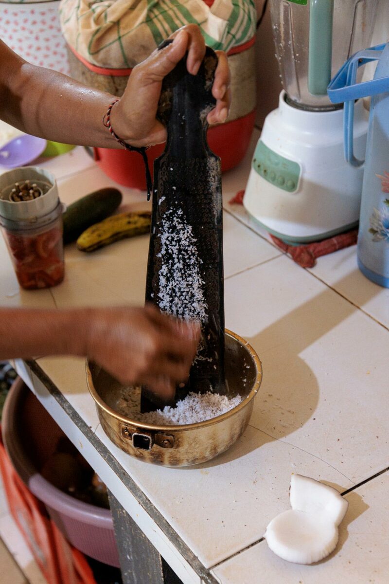 Mama grating coconut to make coconut milk, ubud bali