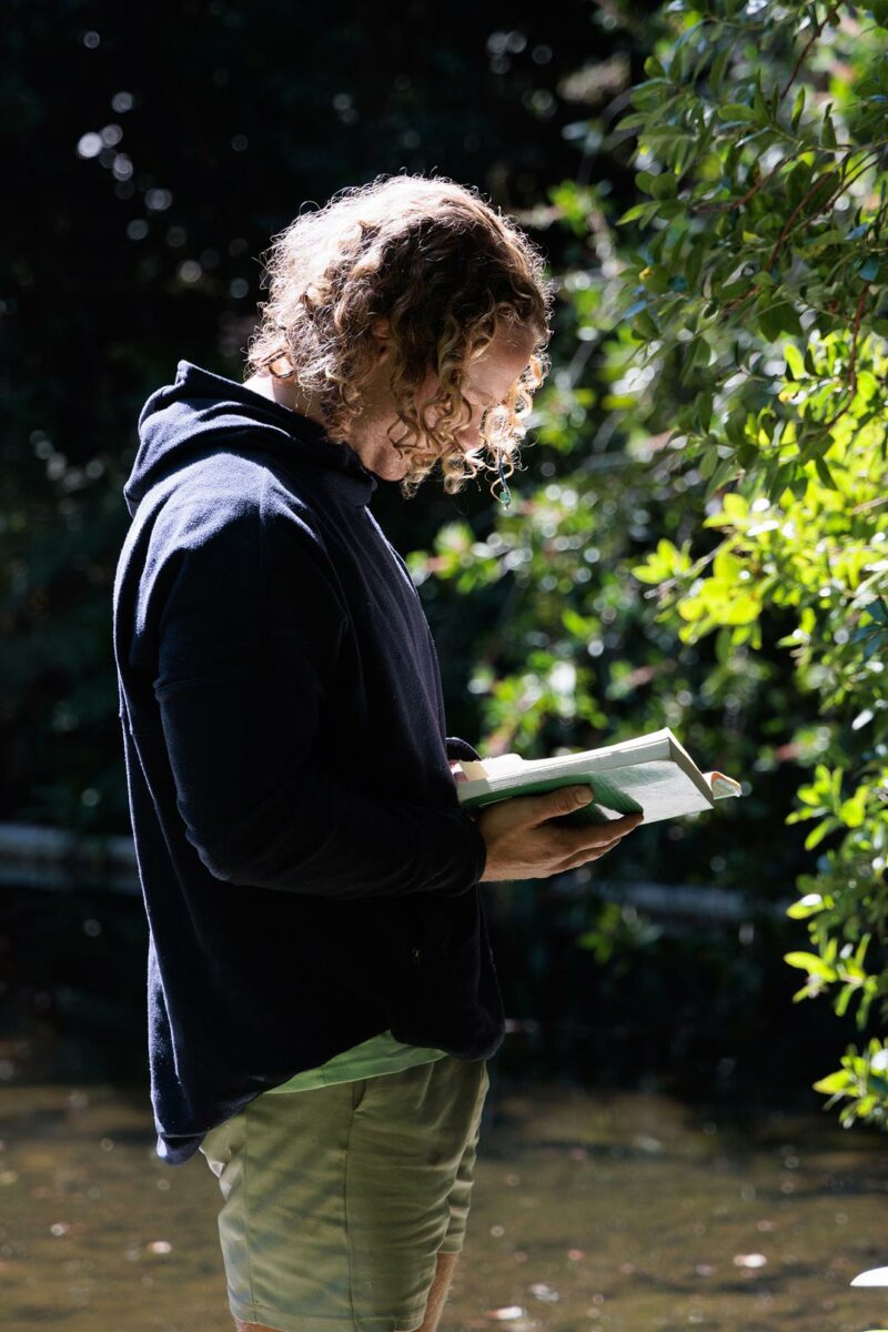 Morning circle, man reading in the forest