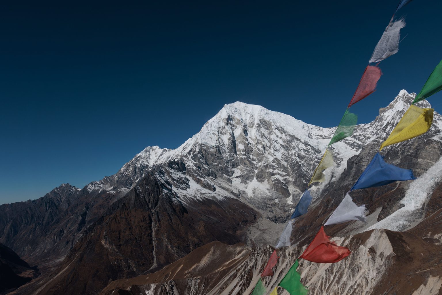 Snowy mountain and prayer flags in langtang valley nepal